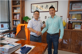 漆強(qiáng)化工張文（左）熱烈歡迎廣東門(mén)業(yè)市場(chǎng)總監(jiān)饒德亮（右）.jpg
